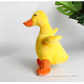 Gelbe Ente kauert Plüschhundspielzeug mit Geräusch